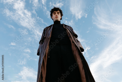 Stylish young male in high neck sweater and trench coat long photo