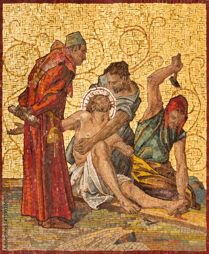 MILAN, ITALY - MARCH 4, 2024: The mosaic Jesus is nailed to the cross as part of Cross way station in the church Chiesa di San Agostino by unknown artist of 20. cent. photo