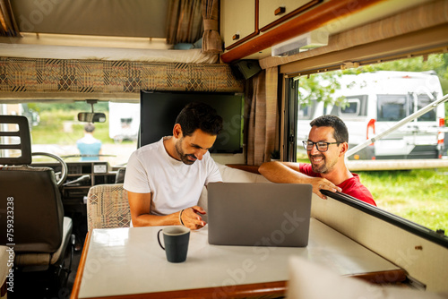 gay couple using laptop in their motorhome