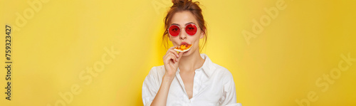 Stylish Woman with Red Sunglasses Savoring a Slice of Pizza, Chic Lunch Break on a Bright Yellow Background