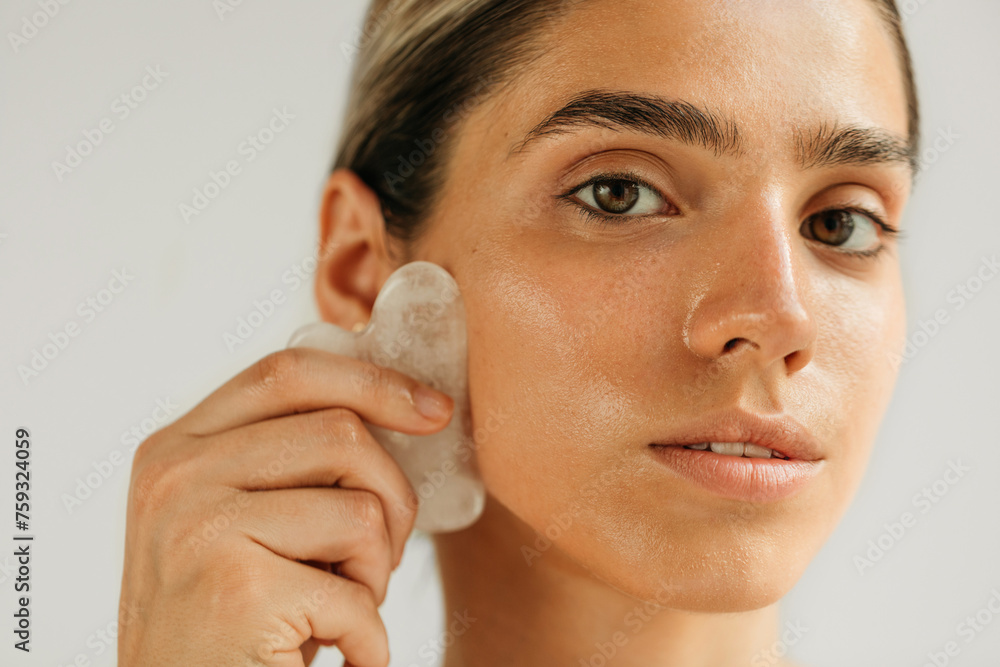 © Studio Firma/Stocksy - Woman Massaging Face