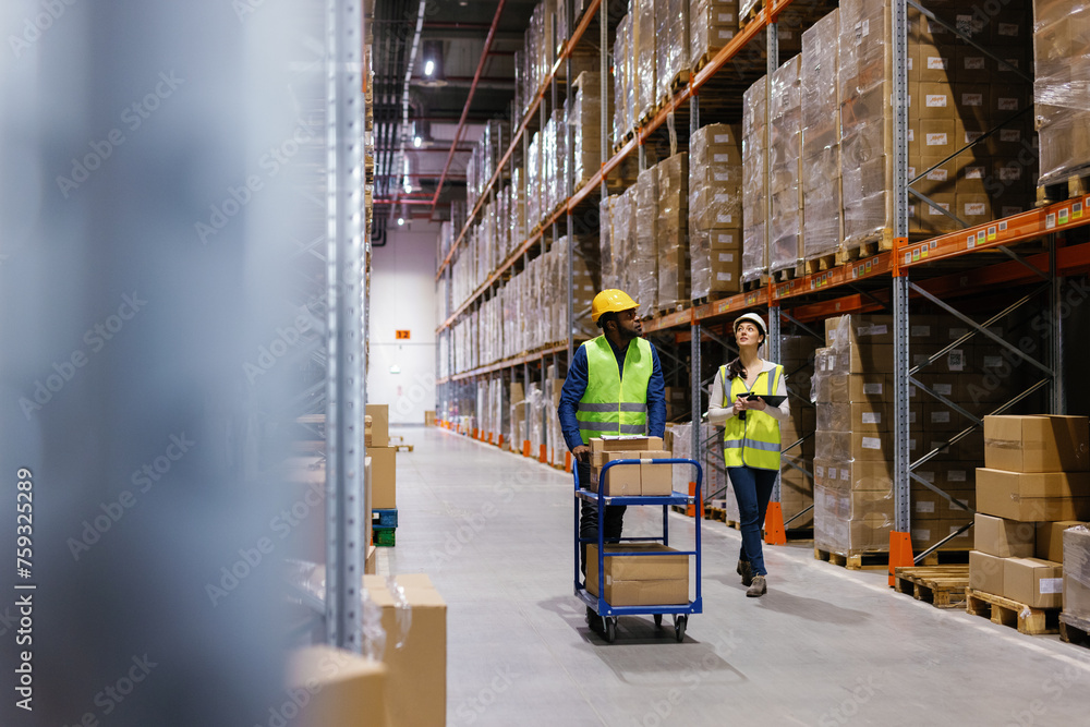 Team warehouse managers walking warehouse aisle Team warehouse managers walking warehouse aisle