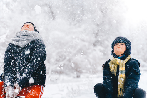 Children catching snowflakes enjoying wintertime 