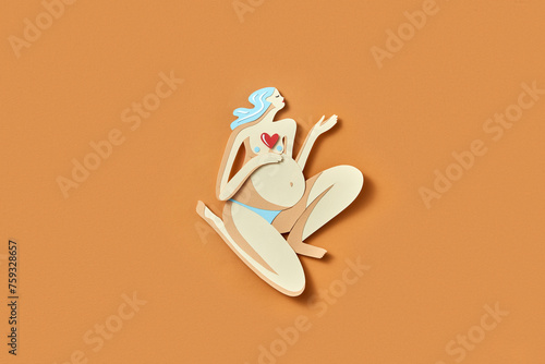 Colorful paper cut pregnant woman with red heart on breast photo