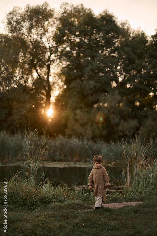 young boy near the pond at sunset
