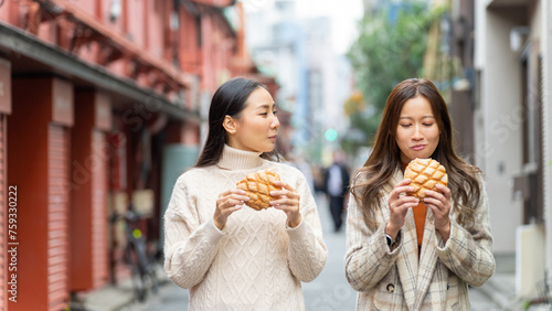 Happy Asian woman eating Japanese sweet bread during travel at Asakusa district  Tokyo  Japan. People enjoy and fun outdoor lifestyle shopping and eating street food in the city on holiday vacation.