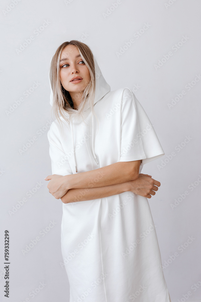 Happy young woman in hoodie standing with crossed hands Happy young woman in hoodie standing with crossed hands