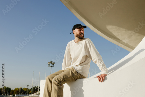 A man is sitting on the parapet of a city building photo