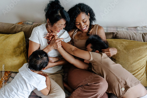 Family romping on couch at home photo