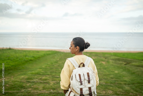 woman walking along a path that leads to the beach photo