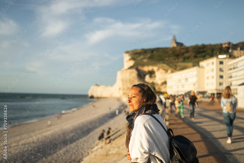 Happy woman looking to see Etretat, Francia beach on a boardwalk Happy woman looking to see Etretat, Francia beach on a boardwalk