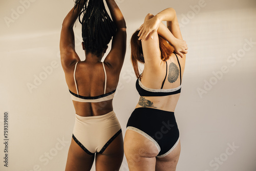 Two women, wearing black and white underwear photo