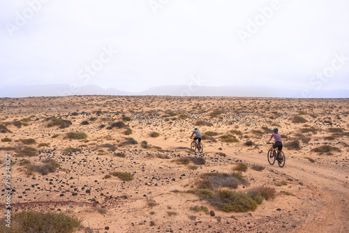 Two cyclists take a ride on the trails of an arid landscape