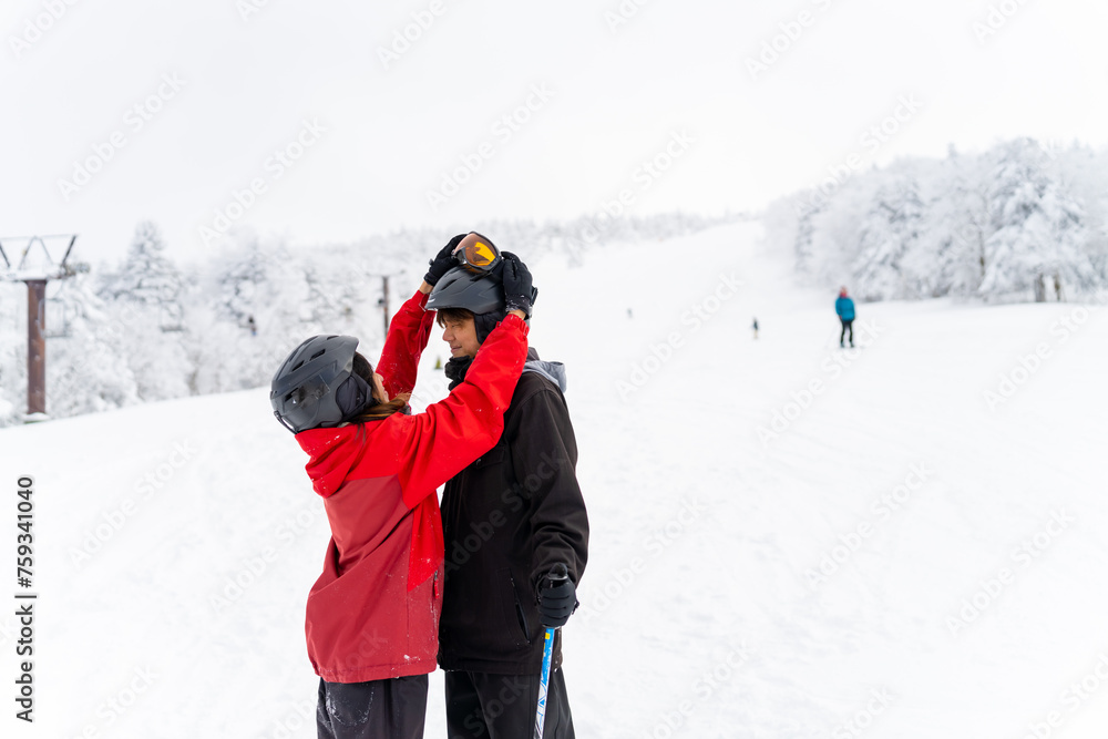 Happy Asian people enjoy outdoor active lifestyle winter extreme sport training on holiday vacation. Man and woman athlete practicing freeride snowboarding and ski at ski resort on snowy mountain.