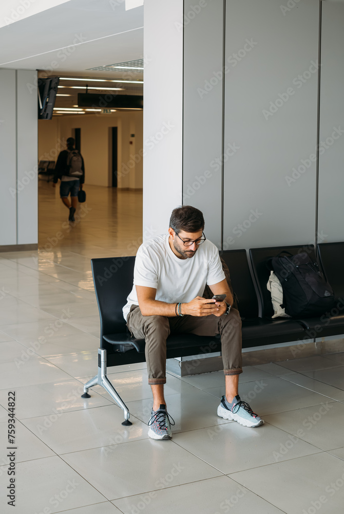 Handsome Man Sitting at Airport and Waiting for Flight Handsome Man Sitting at Airport and Waiting for Flight