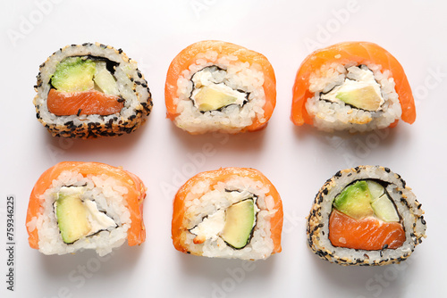Delicious sushi rolls on white background, flat lay
