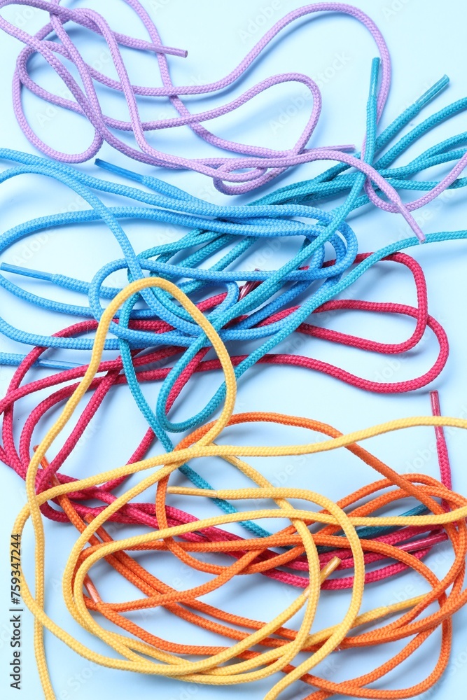 Many colorful shoe laces on light blue background, top view Many colorful shoe laces on light blue background, top view