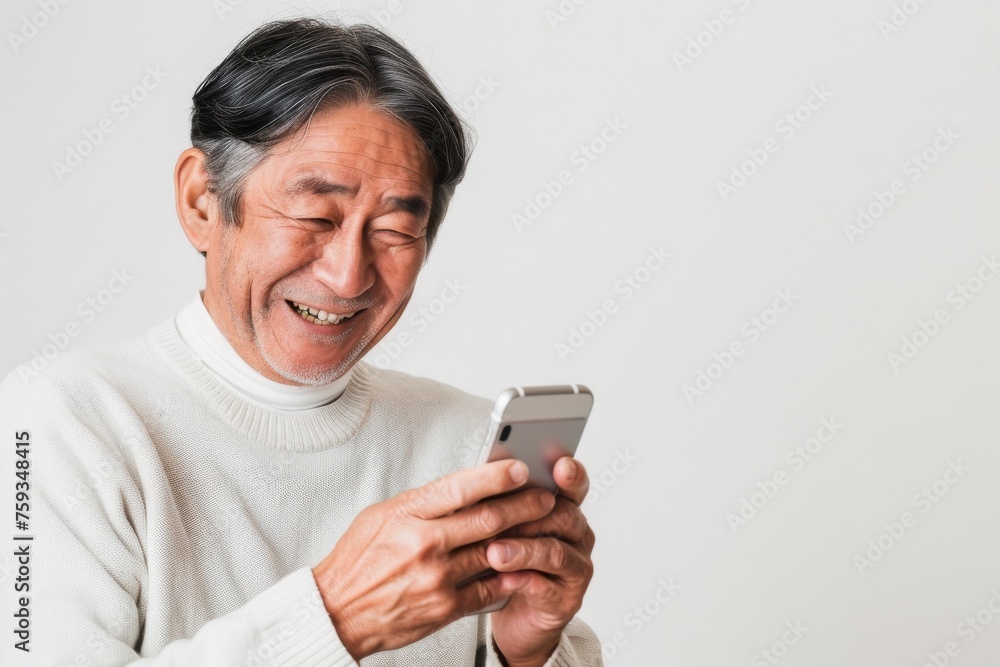 スマートフォンを見て微笑む笑顔のおじいさん(携帯・スマホ・SNS・連絡) スマートフォンを見て微笑む笑顔のおじいさん(携帯・スマホ・SNS・連絡)