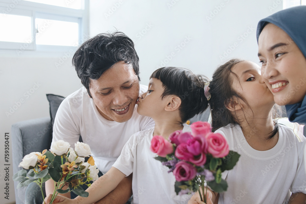 Kids Kissing Parents And Giving Flowers. Son Kiss Father and Daughter Kiss Mother at Home. Family Bonding. Kids Kissing Parents And Giving Flowers. Son Kiss Father and Daughter Kiss Mother at Home. Family Bonding.