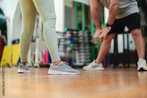 Woman exercising with personal trainer in gym photo