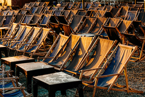 Lots of rows with empty deck chairs in the early morning outdoors