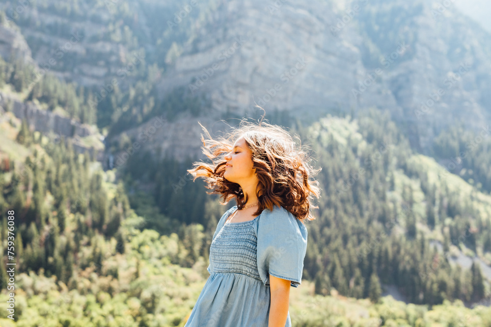 side profile of girl in the mountains with wind blown hair