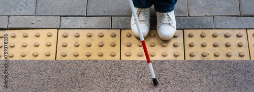 Принти на полотні Close-up of female foot, walking stick and tactile tiles