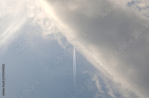 a flying airplane into the huge white cloud photo