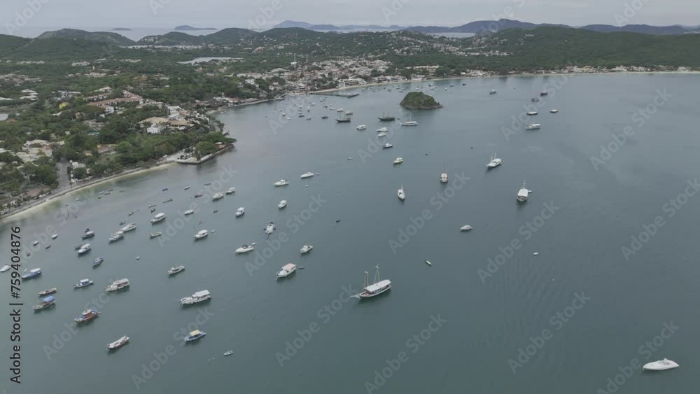 Drone flies forward as it ascends over bay lined with beaches and lots of boats Drone flies forward as it ascends over bay lined with beaches and lots of boats