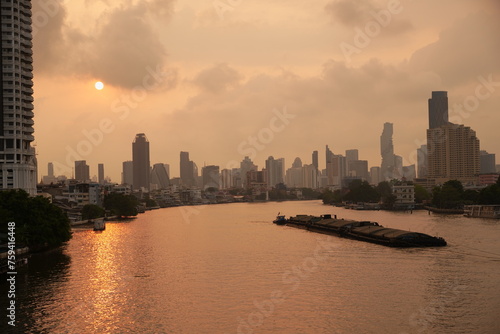 city skyline with a river running through it  urban area during sunset  with vessel in a river
