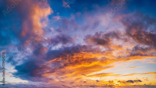 Vibrant sunset sky with colorful clouds, a natural background. © LADALIDI
