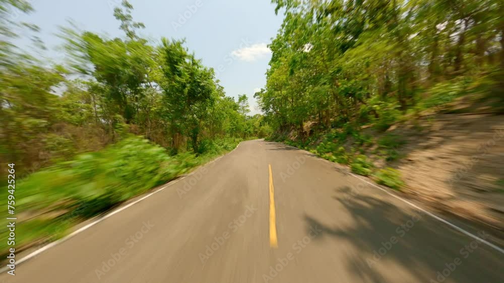 Fast FPV drone flight over the road in the middle of green forest on a sunny summer day, Thailand Fast FPV drone flight over the road in the middle of green forest on a sunny summer day, Thailand
