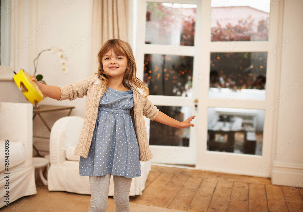 Little, girl and dance with portrait in living room for fun, entertainment and game with musical instrument. Kid, home and tambourine for sound or music to move, freedom and childhood with happiness. Little, girl and dance with portrait in living room for fun, entertainment and game with musical instrument. Kid, home and tambourine for sound or music to move, freedom and childhood with happiness.