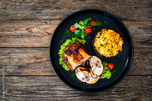 Baked rabbit saddle and vegetable salad on wooden table
