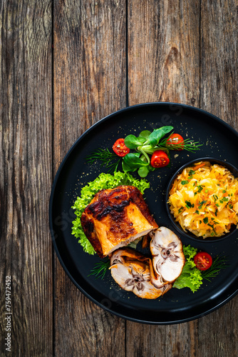 Baked rabbit saddle and vegetable salad on wooden table
