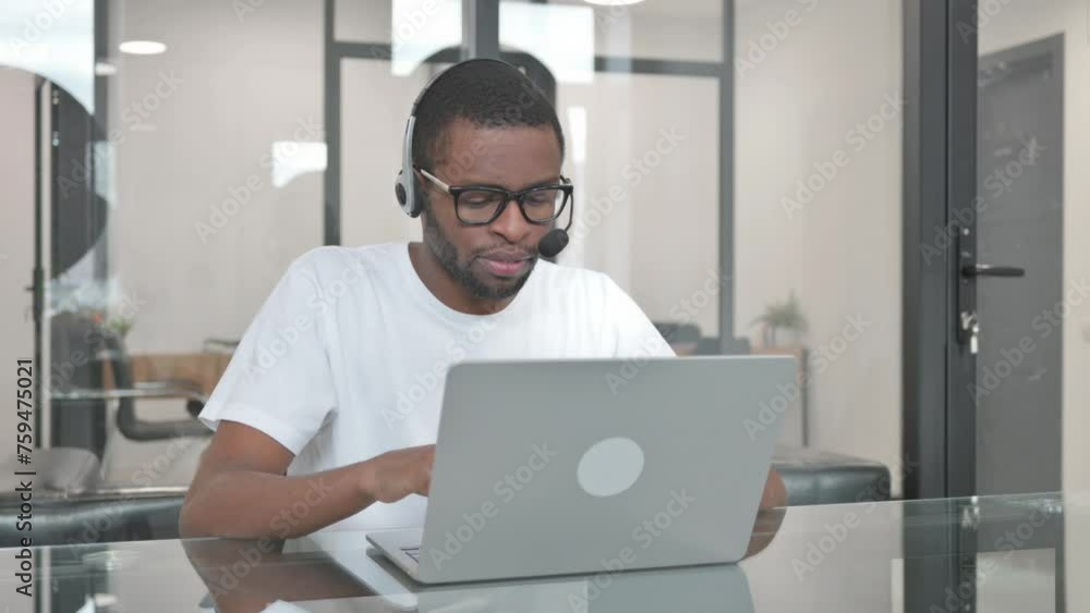 Young African Man with Headset in Call Center Working on Laptop Young African Man with Headset in Call Center Working on Laptop