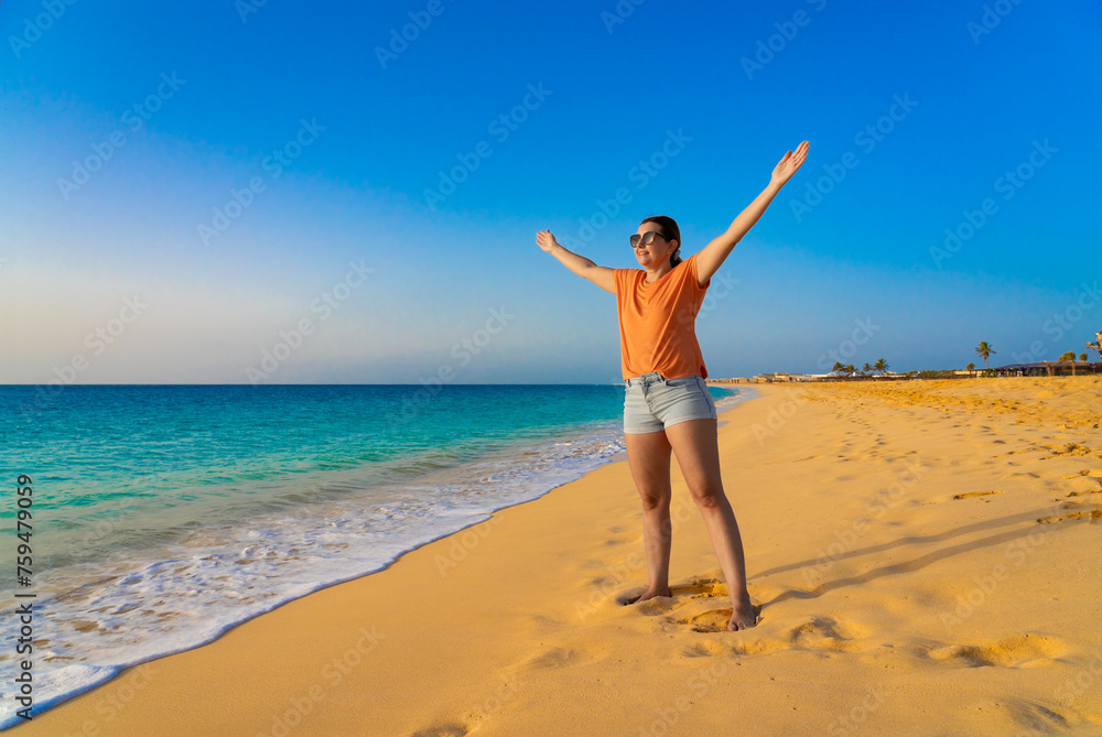 Beautiful mid-adult woman standing on sunny beach Beautiful mid-adult woman standing on sunny beach