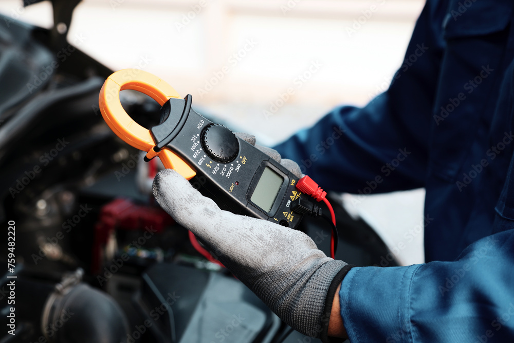 Close-up hand auto mechanic using meter to check car battery fail problem to change repairing and fix car and maintenance servicing. Close-up hand auto mechanic using meter to check car battery fail problem to change repairing and fix car and maintenance servicing.