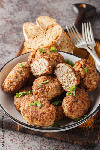 Buckwheat cutlet or Hrechanyky is a dish of Ukrainian which is prepared from minced meat and buckwheat porridge with the addition of onions, spices and herb close-up in a plate on the table. Vertical
