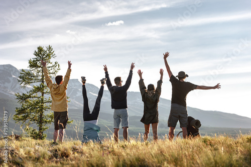 Group of playful happy friends are having fun in mountains and enjoys sunset view