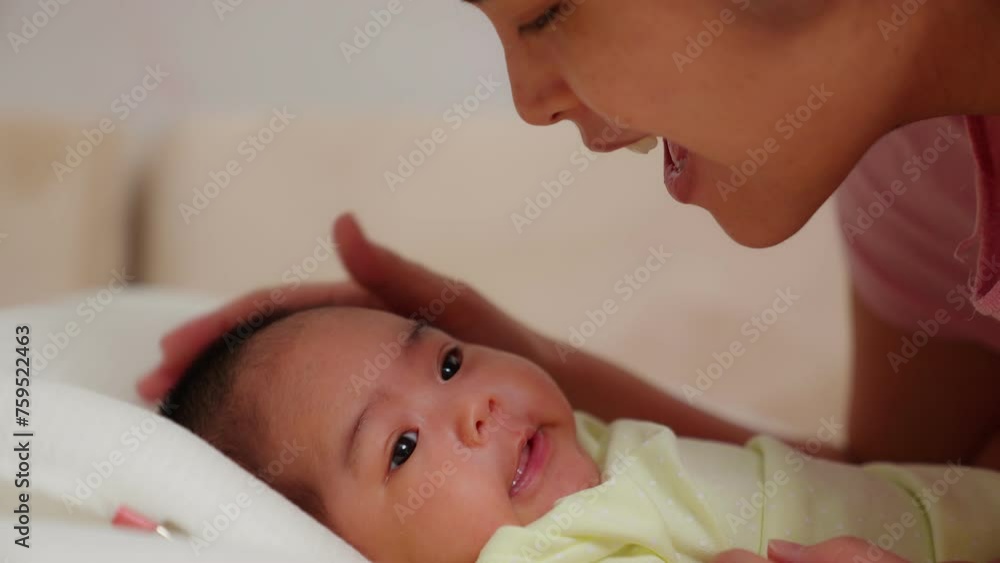 Close up of asian young mother playing with newborn baby smile in a nursery. Parent looking and kiss at infant. Talk, touch, Enhance child's development. Childhood, Maternity, Children, Motherhood. Close up of asian young mother playing with newborn baby smile in a nursery. Parent looking and kiss at infant. Talk, touch, Enhance child's development. Childhood, Maternity, Children, Motherhood.