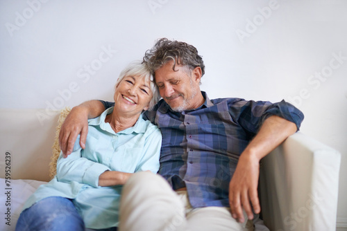 Old couple, hug and relax on sofa with happiness at home, love and security with comfort for bonding. Marriage, partner and retirement together with smile, trust and loyalty with people in lounge © M S/peopleimages.com