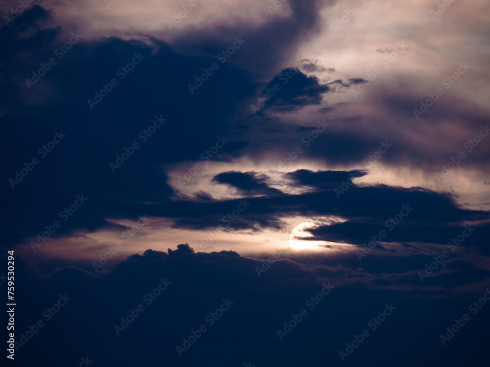Fototapeta premium Rising Sun behind The Dark Streaming Clouds