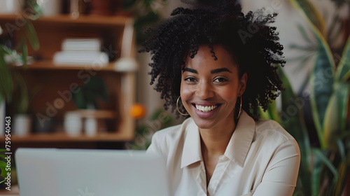 Woman sitting in front of a laptop computer She smiles and she is happy. in modern room