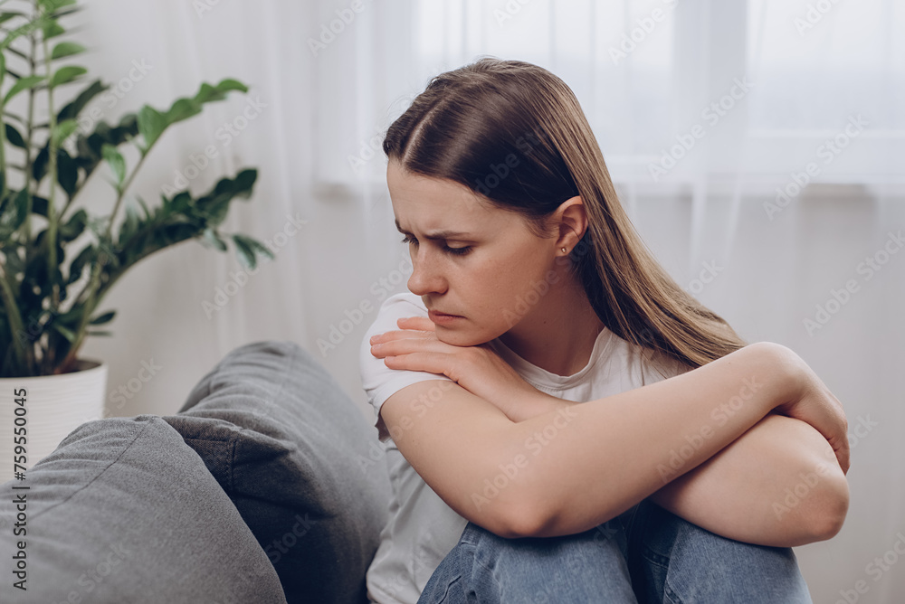 Frustrated confused woman feels unhappy, problems in personal life, quarrel break up with boyfriend and unexpected pregnancy concept. Anxious worried young female sitting alone on couch at home Frustrated confused woman feels unhappy, problems in personal life, quarrel break up with boyfriend and unexpected pregnancy concept. Anxious worried young female sitting alone on couch at home