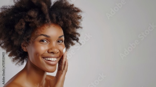 African American woman applying skincare product