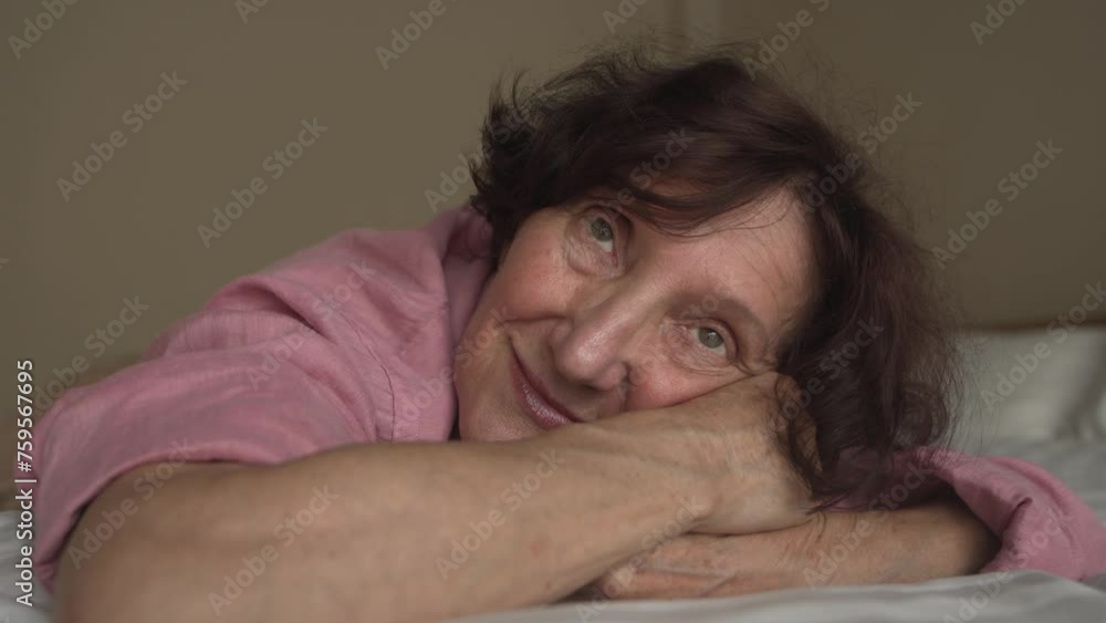 Close-up happy elderly woman smiling and lying on the bed, enjoy life at home. Mature lady with dreamy mood, have a rest, relax, comfort 4K Close-up happy elderly woman smiling and lying on the bed, enjoy life at home. Mature lady with dreamy mood, have a rest, relax, comfort 4K