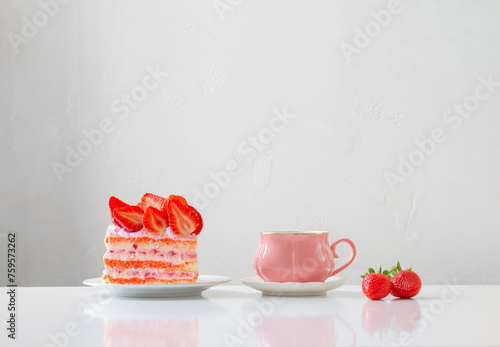 pink cup of coffee and strawberry cake on white background
