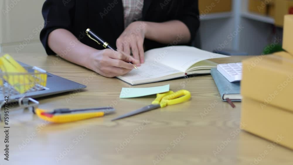 Asian businesswoman works with parcel boxes at home, checking internet orders and preparing parcel boxes for delivery to customers. Woman working at home. Asian businesswoman works with parcel boxes at home, checking internet orders and preparing parcel boxes for delivery to customers. Woman working at home.