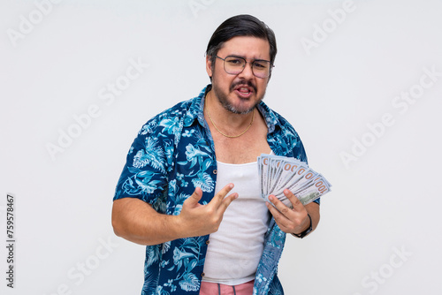 Dodgy and sleazy middle-aged man in a Hawaiian shirt pompously showing off a wad of cash, portraying wealth, standing isolated on a white background. photo